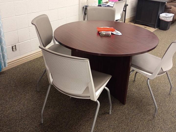 A small meeting room with a round table and four chairs