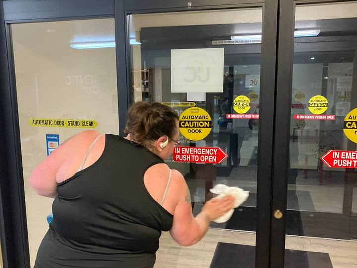 Wiping the glass entry doors of a building