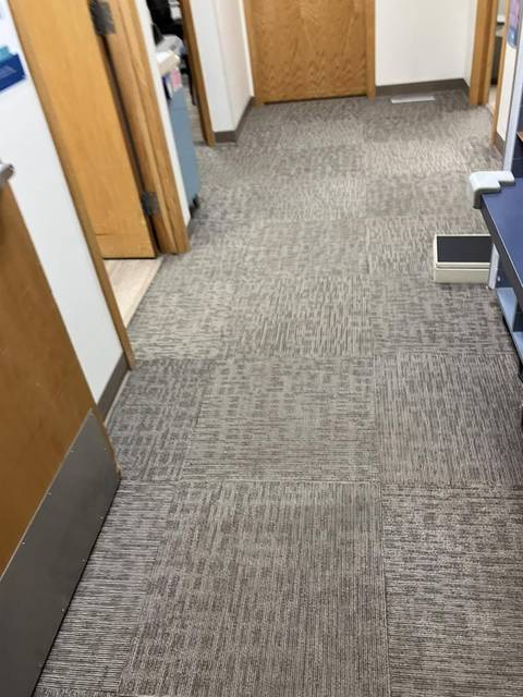 A carpeted office hall with the doors open
