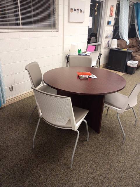 A small meeting room with a round table and four chairs