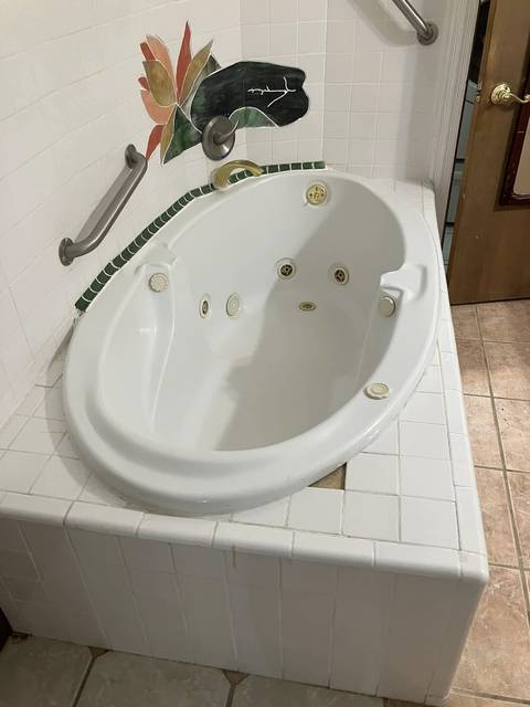 A corner tub set in white tile