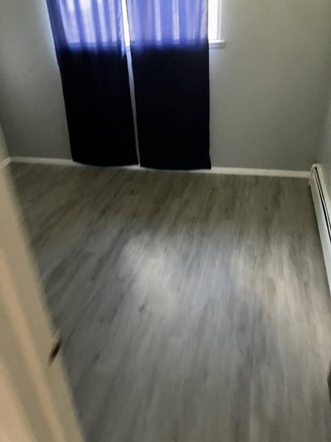 An empty bedroom with a clean plank floor