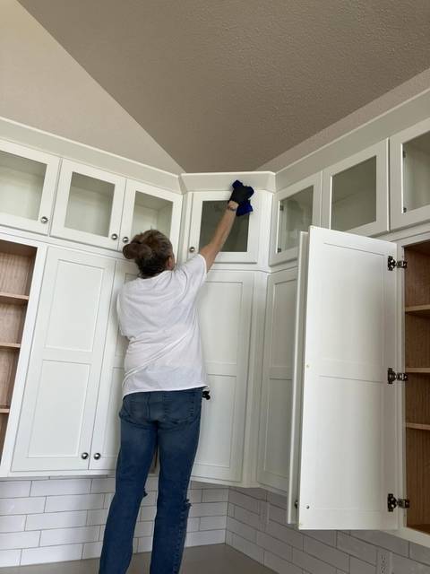 Wiping down white kitchen cabinets