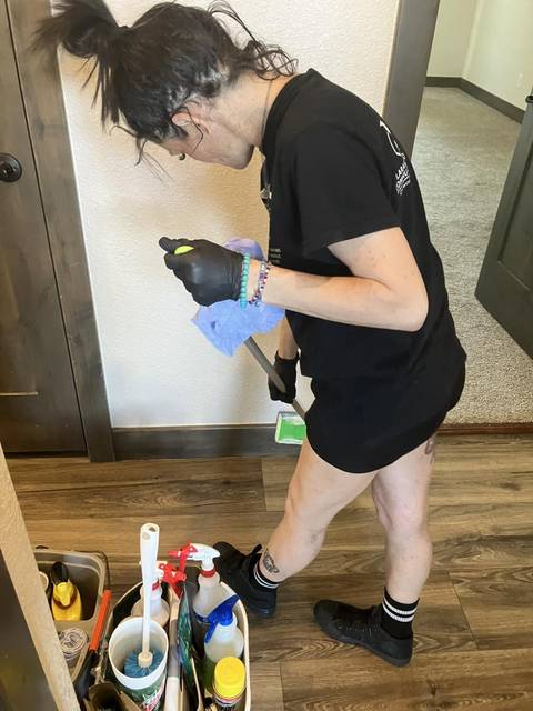 Gloved up with a caddy of supplies on a plank floor